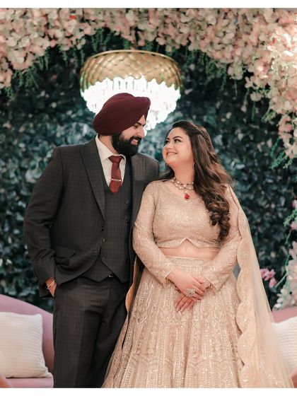 A classic couple portrait in front of a floral arch. Their easy smiles and loving gaze towards each other capture a moment of pure happiness and contentment.