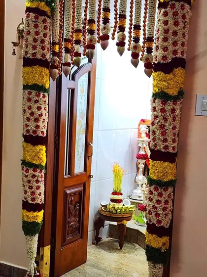 Another beautiful main door decoration with intricate flower pillars, perfect for welcoming guests to a new home.