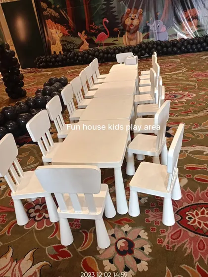 Another view of our white furniture setup at an indoor event in Jaipur. The long table arrangement is perfect for accommodating a larger group of children for dining or activities.