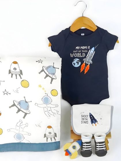 A space-themed baby clothing set. The 'My Mom is Out of This World' onesie is the hero of this shot, which is perfect for social media.