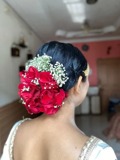 A side view of the traditional red rose bridal bun. The placement of the flowers creates a lush and beautiful effect.
