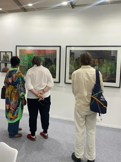 Another group of visitors engaged with Sandeep T K's photographs.