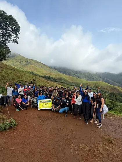 A large group of our trekkers posing with the banner at a viewpoint on the Kudremukha trail.