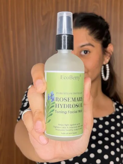 A customer holds up our Rosemary Hydrosol, a magic potion for the skin that wakes you up, banishes blemishes, and leaves you with a radiant glow.