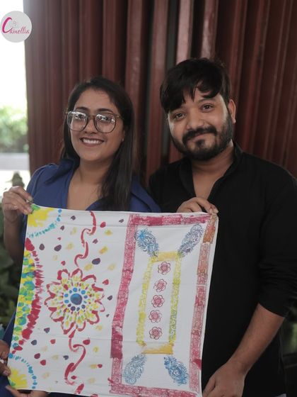 A happy couple shows off the colorful fabric they designed at our block printing workshop. Our events are perfect for creating shared memories.
