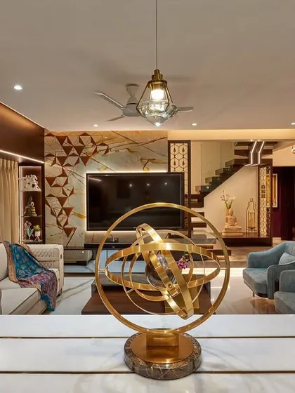 This living room is designed for conversation, with seating arranged around a central art piece. We used a mix of quilted and smooth upholstery, a statement TV backdrop, and elegant pendant lights to complete the look.
