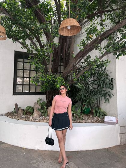 Posing with sunglasses in the casual pink and black outfit.
