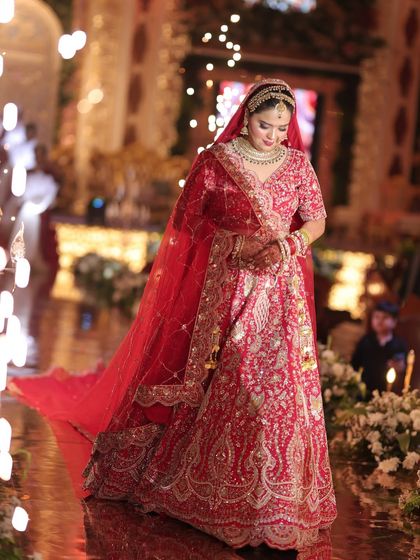 A full-length shot capturing the grandeur of the bridal look. My bride Vidushi looks like a queen in her magnificent red lehenga, with makeup designed to be flawless from every angle.