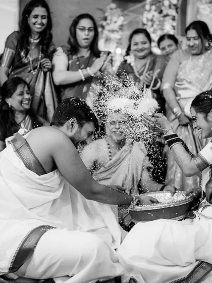 The 'Talambralu' ritual frozen in time. This dynamic black and white shot captures the joyful chaos of the rice-showering ceremony.