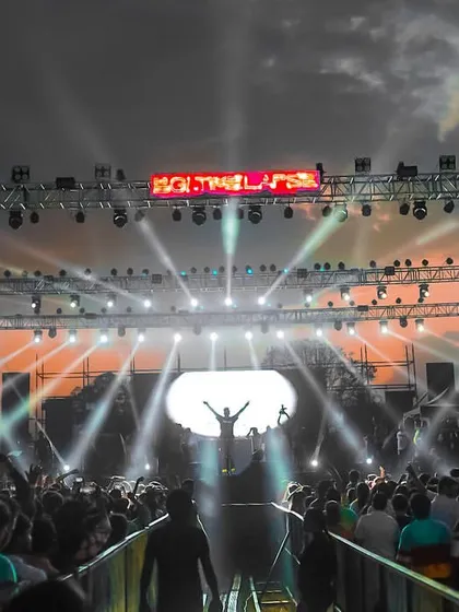 A silhouette of me against the sunset-colored sky at the BGI festival. This epic shot captures the scale and beauty of an outdoor music event.