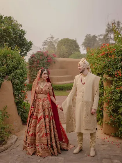 A beautiful portrait of Karna and Ted in the misty gardens of The Oberoi Rajvilas. The soft winter light and lush surroundings create a romantic and timeless image.