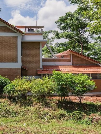 A beautiful farmhouse project surrounded by lush greenery. This image represents our love for creating buildings that belong to their landscape, using natural materials that complement the environment.
