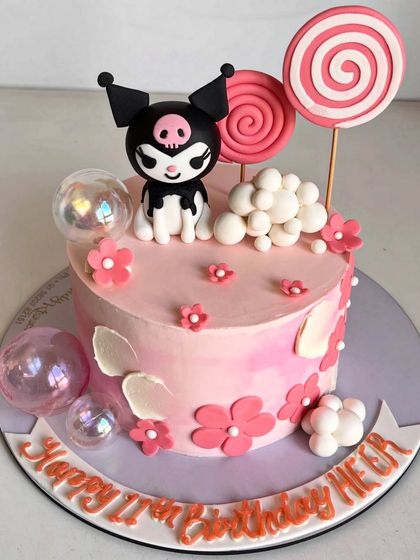 A full view of the cute and chaotic Kuromi-themed cake, showing all the fun details like lollipops, bubble toppers, and floral accents.