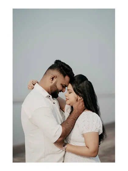 An intimate embrace by the sea, focusing on the couple's connection with a clean, minimalist background.