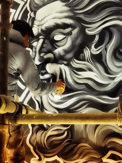 A shot of me working on a massive monochrome portrait of a Greek god. Perched on scaffolding, I used spray paint to create the soft gradients and flowing hair.