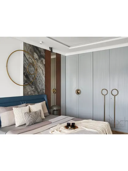 A view of the master bedroom's custom wardrobe, which features a soft pastel grey finish and unique circular brass handles. The fluted texture adds a subtle, classical detail to the modern design.