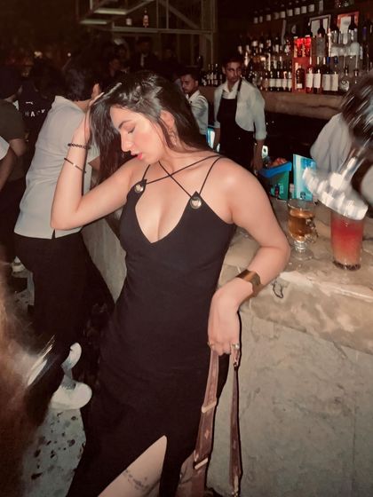 Another candid from a night out, leaning against the bar in my black dress. These are the unposed moments that capture the real vibe.
