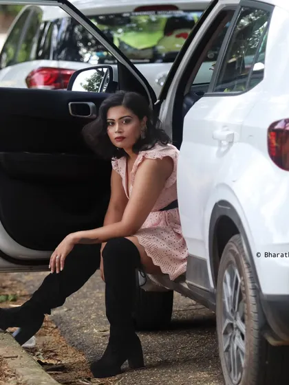 The same model and outfit, posed by a white car. This shot has a more urban, on-the-go feel.