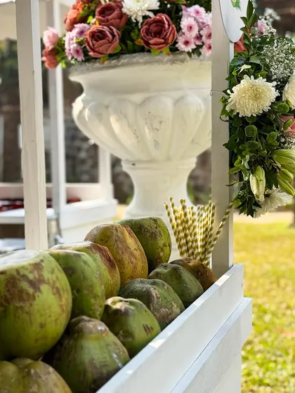 A beautiful shot of the fresh coconut cart, decorated with a stunning floral arrangement. This shows how even a simple beverage station can be transformed into an elegant decor element.