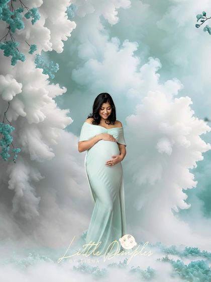 A dreamy, ethereal portrait created with a beautiful mint green gown and a magical, cloudy backdrop. This style is perfect for capturing the wonder of pregnancy.