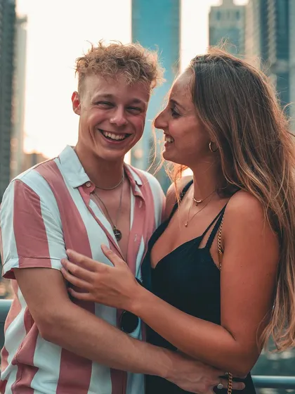 A joyful, candid moment between a couple against a modern city skyline. This photo captures the energy and excitement of their love story in an urban setting.