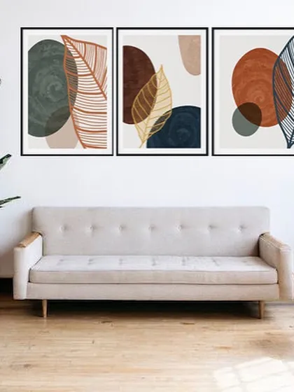 A set of three framed prints that combines abstract shapes with delicate leaf line art. The earthy tones and varied compositions create a beautiful and cohesive triptych that brings a touch of nature indoors.