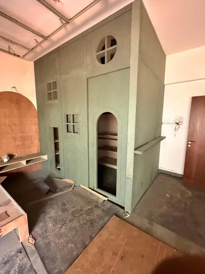 The dollhouse-themed wardrobe from image 55 under construction, showing the design being brought to life.