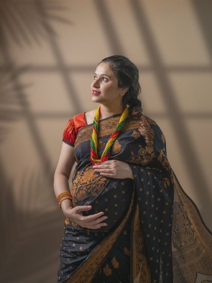 Grace in tradition. The soft play of light, the intricate details of the black and gold saree, and her radiant glow all speak of timeless beauty.
