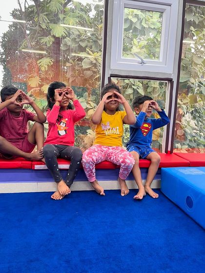 Four friends take a break, making funny "binoculars" with their hands. Moments of imaginative play and friendship are a huge part of the experience at my gym.