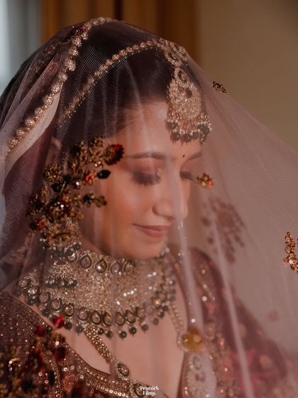 A beautiful close-up of the bride through her veil. The intricate embroidery and her gentle smile create a portrait that is both delicate and full of emotion.