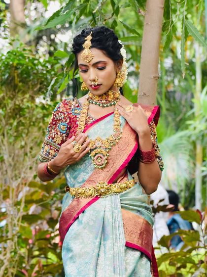 This series showcases a model in a beautiful light blue saree, adorned with a full temple jewellery set. The outdoor setting highlights the richness of the antique gold finish.