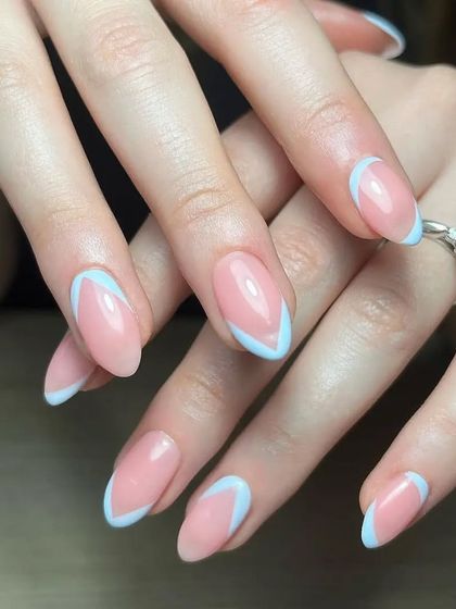 A modern V-French manicure with light blue tips on almond-shaped nails, offering a subtle and stylish look.