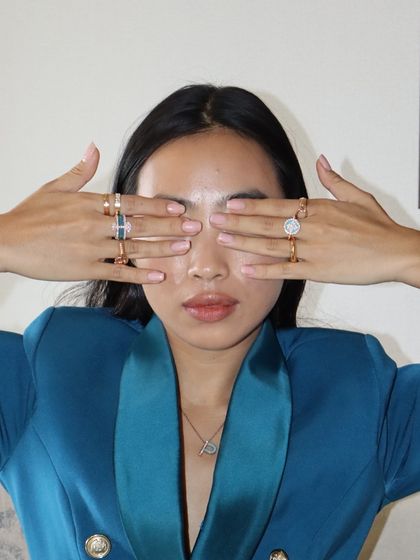 A playful shot showcasing our custom initial pendant and a full stack of colourful enamel and diamond rings.