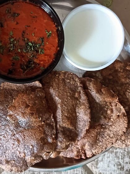 A traditional fasting meal of Vrat wali Poori made from kuttu atta (buckwheat flour), served with a simple aloo tamatar sabzi and curd.