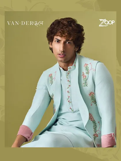 A pastel blue kurta set with a matching jacket featuring delicate pink floral embroidery. This piece from the Vanderphool collection is perfect for a spring or summer wedding ceremony.