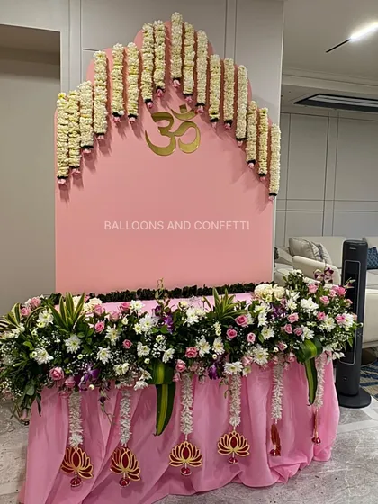 For Ganesh Chaturthi, I focus on creating a peaceful and modern space. This setup features a clean, pink arched backdrop with a golden 'Om' symbol, complemented by a cascade of fresh tuberose garlands. The base is heavily decorated with a mix of white and pink flowers, creating a serene and beautiful corner to welcome Bappa.