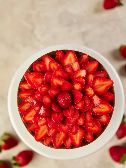 An overhead view of our Chocolate & Strawberry cake, where fresh, thinly sliced Mahabaleshwar strawberries are arranged to look like a blooming flower. This design highlights our commitment to using beautiful, seasonal ingredients as the star of the show.