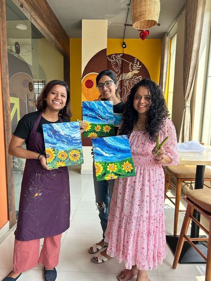 Smiles all around! This happy group proudly displays their sunflower paintings, created using knife and finger painting techniques during one of our weekend workshops.