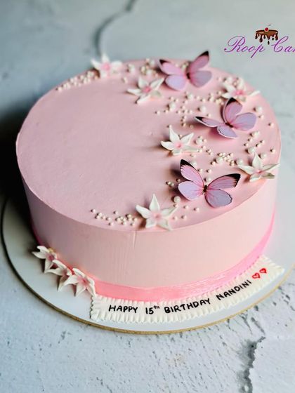 Simplicity in pink. A beautiful and elegant cake with delicate butterfly and flower accents.