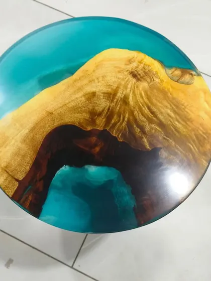 A stunning top-down view of a finished river table. The turquoise resin contrasts beautifully with the rich, dark wood, creating a striking visual effect.