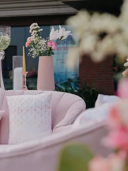 A detail of the lounge seating at Yasha and Rahil's blush wedding, with a focus on the soft pink sofa and elegant floral arrangements.