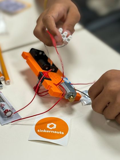 A close-up of a child connecting wires on their project at the Yahoo event. Their focus and determination are what make these events so rewarding.