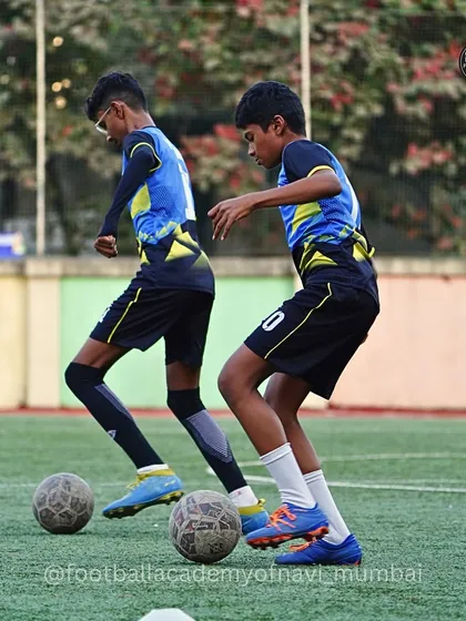 Players work in pairs on close-control dribbling drills, pushing each other to improve.