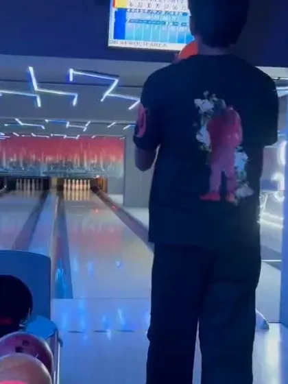 A player stands ready at the bowling lane, with the scoreboard visible in the background, during one of our league matches.