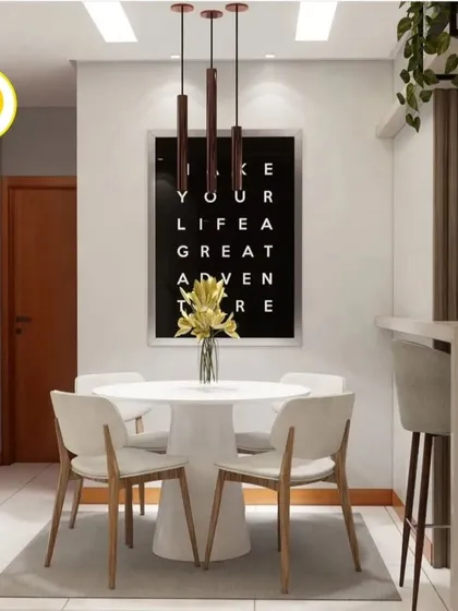 A close-up of the dining area, featuring a white round table and a bold typographic artwork. The design is simple, modern, and perfect for a compact apartment.