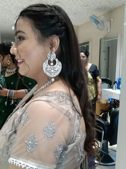 Another angle showcasing the detailed side-braid and soft curls we did for this party-ready hairstyle.