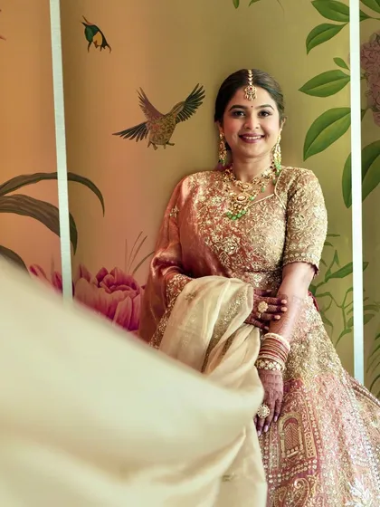 A playful shot with the dupatta creating movement. Her makeup remains flawless and radiant, capturing the happy energy of the moment.