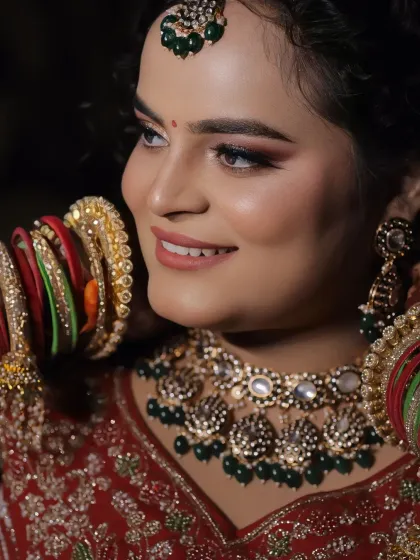 A candid shot capturing the bride's happy expression. The side profile highlights the contouring, blush, and the intricate details of her colorful bangles.