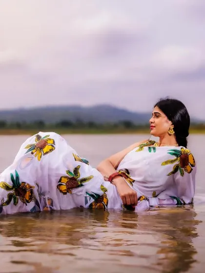 A dreamy and contemplative pose, reclining in the water. This shot is artistic and ethereal, blending fashion with nature in a beautiful way.