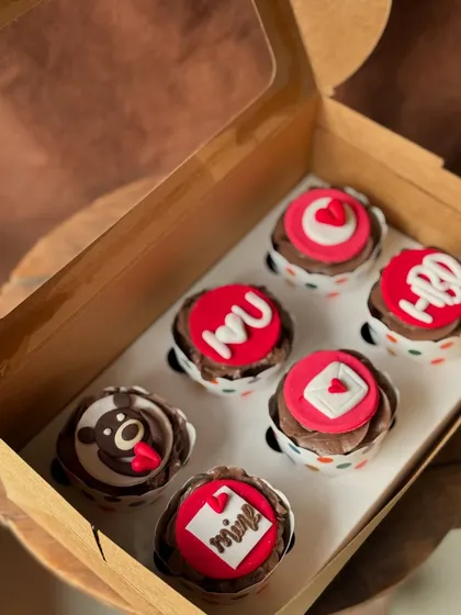 Say "I love you" with a box of sweet treats. These chocolate cupcakes are decorated with cute, romantic fondant messages and shapes, perfect for anniversaries, birthdays, or just because.